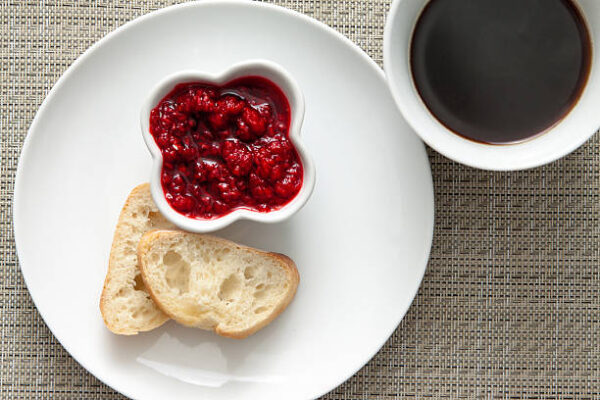 Light breakfast with fresh bread, homemade raspberry jam, coffee .